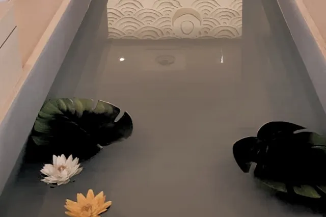 La salle zen : un bassin traverse la salle, fleurs de lotus sur l’eau